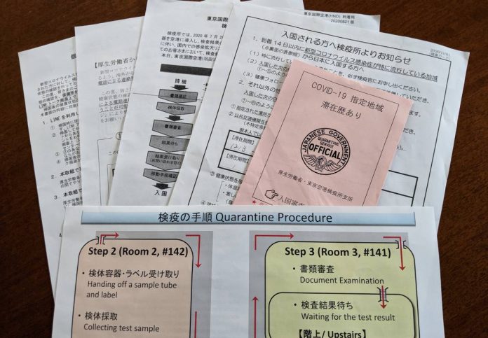 機内で配られた書類と検査後に渡された赤紙。Photo by © The Vancovuer Shinpo
