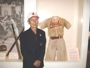 22005年、『朝日軍遺産展覧会』にカナダ野球殿堂から受け取ったジャケットを着て出席したケイ上西さん。思い出のユニフォームはこのとき日系博物館に寄付した　© The Vancouver Shinpo