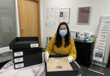 バンクーバー新報のバックナンバー、日系博物館へ 寄贈されたバンクーバー新報を、長期間保存のためアーカイブ用保管ボックスに入れて整理する、NNMCCのコレクションマネージャー、リサ・ウエダさん Photo Courtesy of Nikkei National Museum & Cultural Centre