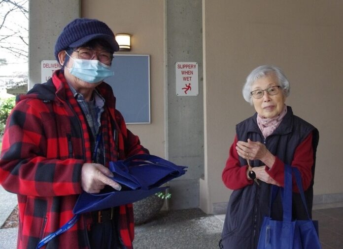 利用者にお弁当を届ける茂泉さん　©The Vancouver Shinpo