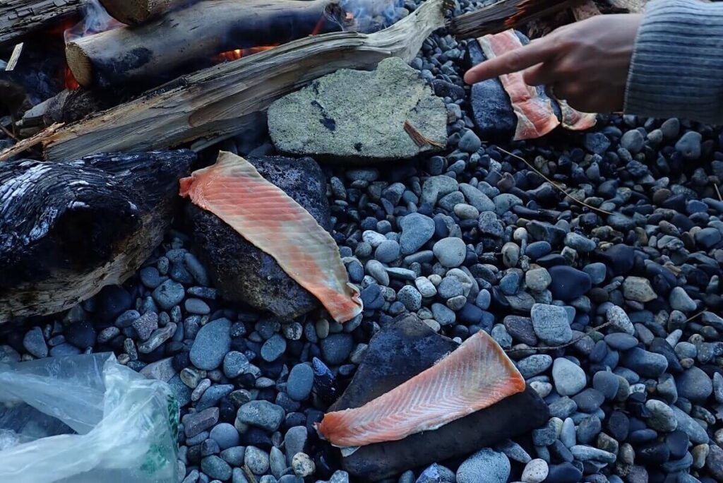 鮭皮は焚き火で熱した石で石焼きに。©Hideo Noguchi
