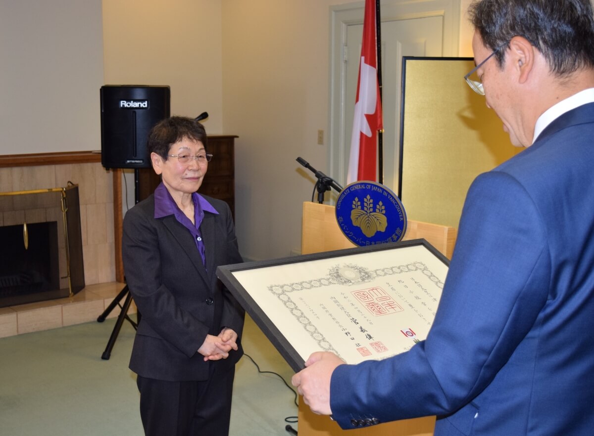 羽鳥総領事が読み上げる勲記に神妙な面持ちの津田氏。Photo by © the Vancouver Shinpo