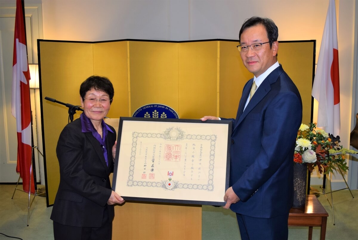津田佐江子氏の旭日小綬章、叙勲伝達式、なごやかに 津田氏(左)と羽鳥総領事。勲記授与のあと記念撮影。Photo by © the Vancouver Shinpo