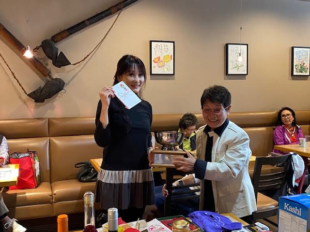優勝した鹿内さんにはバンクーバー新報元社主の津田佐江子さんからトロフィー、賞金、松茸が渡された。写真提供　塩入勝子さん