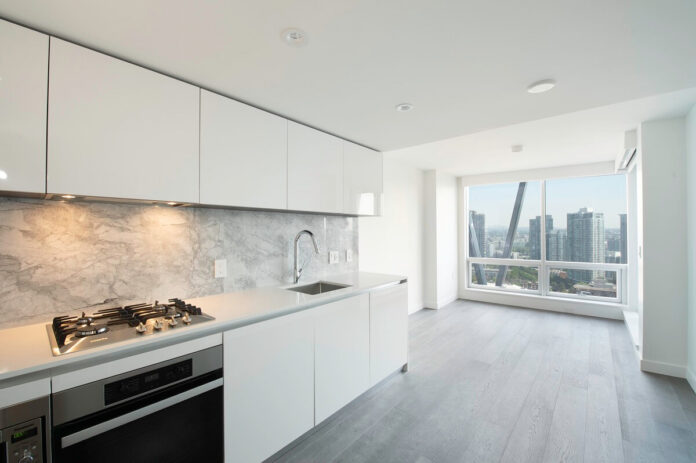 光沢を抑えたブラッシング仕上げのキッチンキャビネットが人気。Photo courtesy of Oak West Realty Ltd.