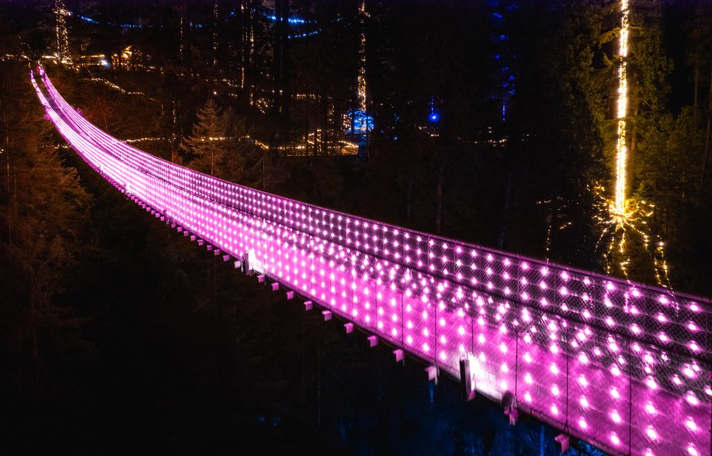 キャピラノ吊り橋がピンクのライトでライトアップされる。Photo courtesy of Capilano Suspension Bridge Park