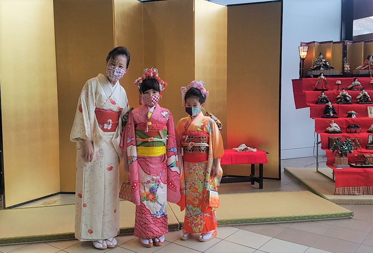 家族連れが楽しんだ日系センターのファミリーデーイベント 3月3日桃の節句に合わせて行われた着付けのデモンストレーションでモデルとして活躍した、8歳のRinaちゃんと6歳のRionaちゃん。ホーランさんと。©The Vancouver Shinpo