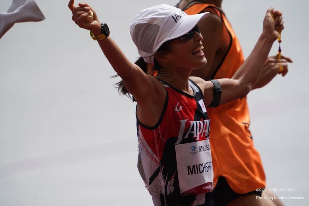 女子マラソンで金メダルを獲得した道下美里選手。伴走するガイドと共に笑顔でゴールへ。2021年東京パラリンピック。Photo by Manto Artworks