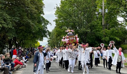 よい　よいとー！と掛け声をかけながら神輿がニューウエストミンスターの街を行進。沿道の観客も日本の祭事を食い入るように見つめていた（晩香坡櫻會写真著作権）