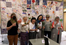 リンダ・オオハマ監督制作ドキュメンタリー映画「東北の新月(A New Moon Over Tohoku)」チャリティ上映会 上映会スタッフとキルトの前で記念撮影を行うリンダ監督(右から3番目)。2022年6月24日、バンクーバー市バンクーバーユニタリアン教会。(提供:上映会スタッフ)