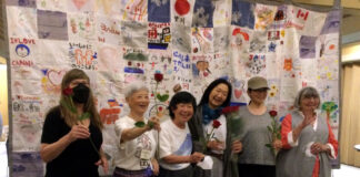 リンダ・オオハマ監督制作ドキュメンタリー映画「東北の新月(A New Moon Over Tohoku)」チャリティ上映会 上映会スタッフとキルトの前で記念撮影を行うリンダ監督(右から3番目)。2022年6月24日、バンクーバー市バンクーバーユニタリアン教会。(提供:上映会スタッフ)
