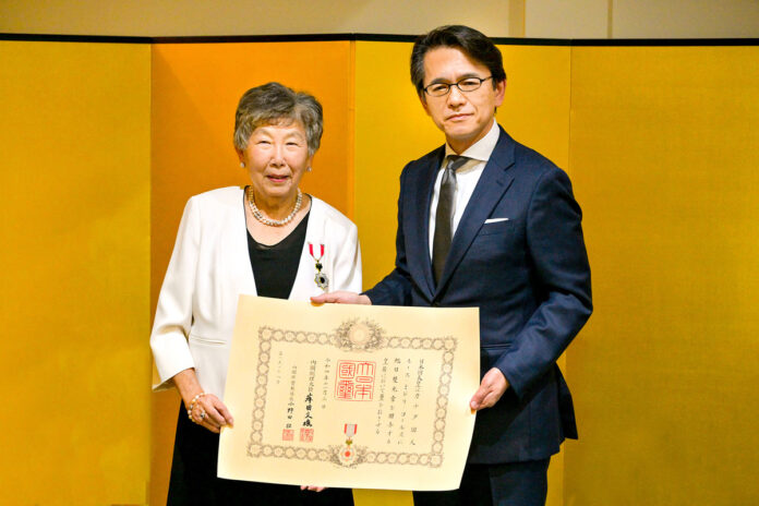 勲章を胸に、勲記を手にするコールズ氏（左）、丸山総領事と。2022年12月27日、在バンクーバー日本国総領事公邸。Photo by ©Koichi Saito