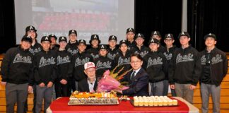 朝日ベースボール遠征メンバー発表、上西ケイさん101歳を祝福 丸山総領事(前列右)から贈られた花束を手に、101歳の祝福を受ける上西ケイさん(前列左)。朝日ジャパンツアー選抜選手に囲まれて。2023年1月22日、日系文化センター・博物館。Photo by ©Koichi Saito