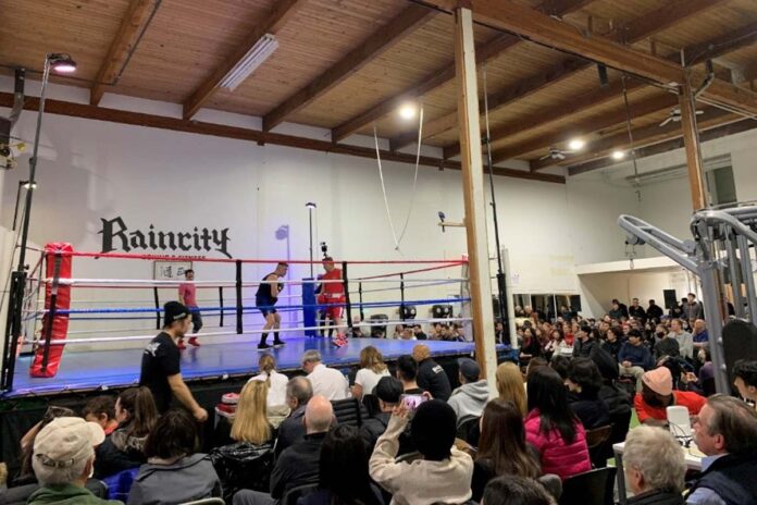 集まった大勢の観客を前に熱い戦いを見せる吉川英治さん（右）と全カナダチャンピオンRobert Couzensさん。2023年2月11日、Raincity Boxing Studio（リッチモンド市）。撮影：池田茜音/日加トゥデイ
