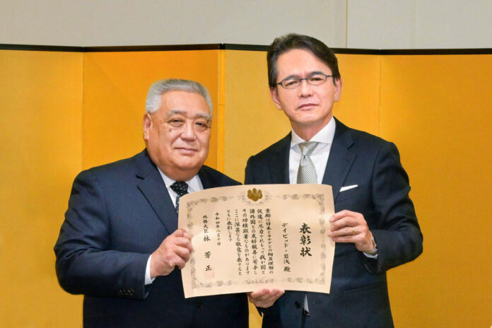 表彰を手にするデイビッド岩浅氏（左）と丸山浩平総領事。2023年1月31日、在バンクーバー日本国総領事公邸。Photo by Koichi Saito