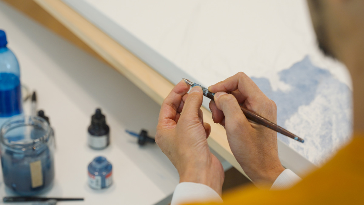 池田さんの手とペン。オデイン美術館/ウィスラー。Photo by Leo FK/Japan Canada Today