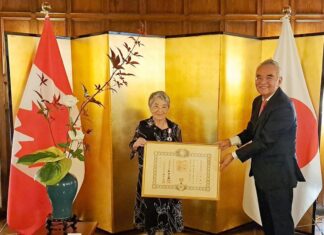叙勲受章グレース・トミコ・フルヤ氏への勲記・勲章伝達式が在カナダ日本国大使公邸で行われる 勲記を手にするフルヤ氏(左)と山野内大使。2023年7月28日、オンタリオ州オタワ市。写真提供:在カナダ日本国大使館