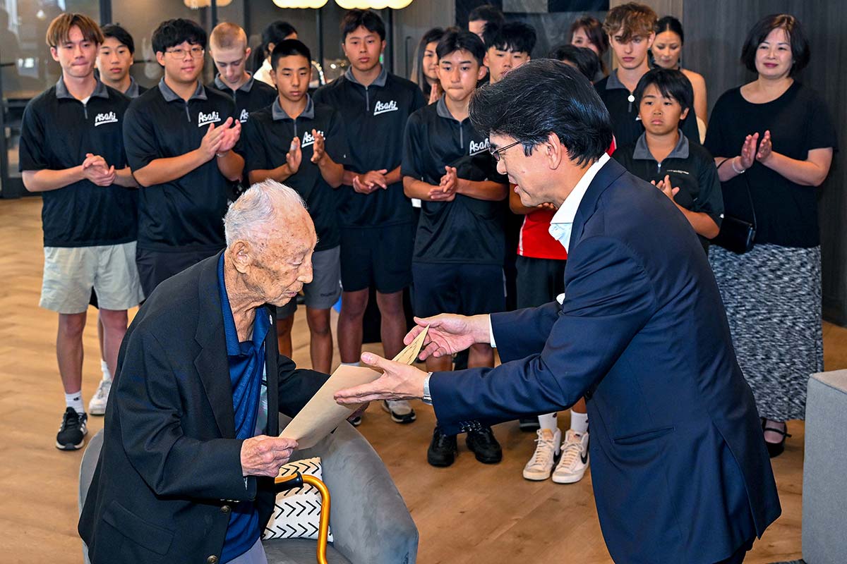 表彰状を受け取る上西氏（左）と丸山総領事。それを見届ける朝日チームの選手たち。2023年8月14日、バンクーバー市内。Photo by Koichi Saito