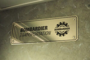 ＷＣＥの２階建て客車内に取り付けられた「ボンバルディア・トランスポーテーション」の銘板（２３年１２月２２日、バンクーバーで大塚圭一郎撮影）
