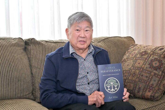 アート・ミキさん。著書「Gaman」を手に。2024年4月、リッチモンド市で。撮影　斉藤光一