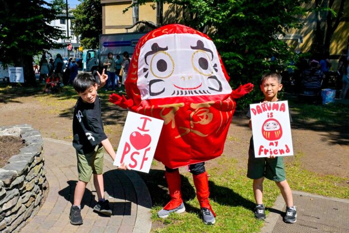 パウエル祭の人気者ダルマと一緒に。「ダルマと一緒に写真を撮ろう！」のイベントも開催されていた。2024年8月3日、バンクーバー市。Photo by Koichi Saito/Japan Canada Today
