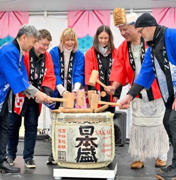 バンクーバー桜まつり2025開幕、雨模様も元気いっぱいの開会式 開会式での鏡開き。左端に髙橋総領事、左から3番目がリンダさん。2025年3月29日、バンクーバー市。撮影 斉藤光一