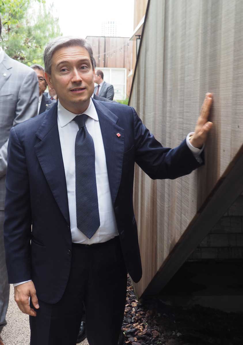 2017年5月に「ログロード代官山」のカナダ産木材の外壁に触れるシャンパーニュ氏(提供写真)