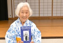 「カナダから被爆体験を語り継ぐ 終戦80年、世界に平和の種を届けて」ランメル幸さんインタビュー 著書「Hiroshima-Memories of a Survivor」を持ち笑顔を見せるランメル幸さん。2025年7月5日、バンクーバー市。Photo by Koichi Saito