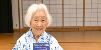 「カナダから被爆体験を語り継ぐ 終戦80年、世界に平和の種を届けて」ランメル幸さんインタビュー 著書「Hiroshima-Memories of a Survivor」を持ち笑顔を見せるランメル幸さん。2025年7月5日、バンクーバー市。Photo by Koichi Saito