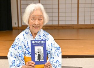 「カナダから被爆体験を語り継ぐ 終戦80年、世界に平和の種を届けて」ランメル幸さんインタビュー 著書「Hiroshima-Memories of a Survivor」を持ち笑顔を見せるランメル幸さん。2025年7月5日、バンクーバー市。Photo by Koichi Saito