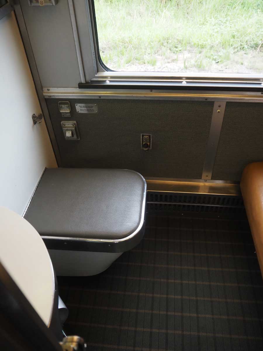 「寝台車プラスクラス」の1人用個室の寝台を片付けた状態。左側のふたを開けると中には…(大塚圭一郎撮影)
