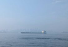 メトロバンクーバーに大気質警報、バンクーバーの空が真っ白に ノースバンクーバーから臨むバンクーバー・ダウンタウンが山火事の影響でかすみ、タンカーの向こうにかすかに見える。2025年9月3日、ノースバンクーバー市。写真 日加トゥデイ