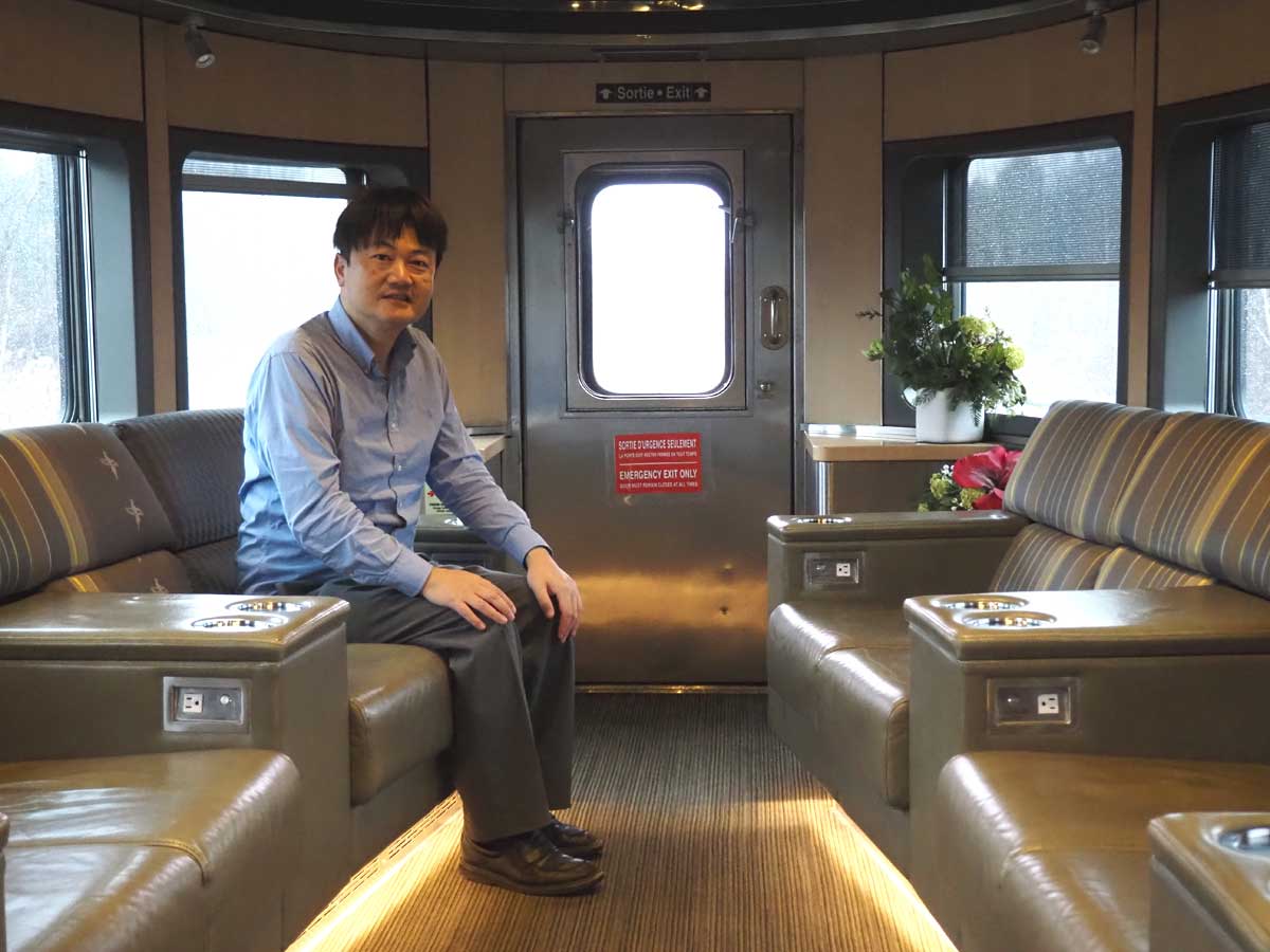VIA鉄道カナダの列車「カナディアン」のパークカーの最後尾にあるソファに座る筆者