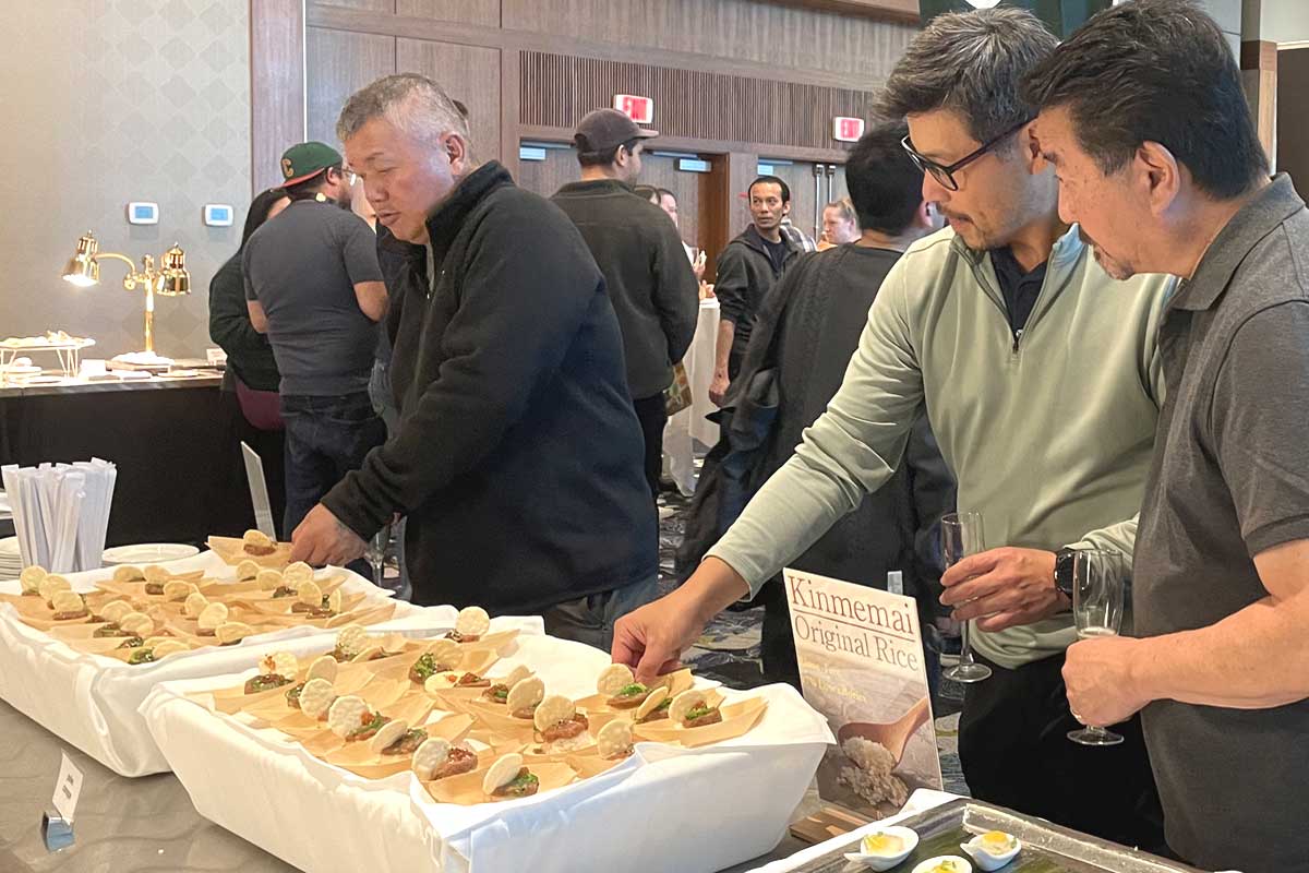 金芽米を使った料理に興味を示す来場者。他にも日本酒に合わせた料理が並んだ。2025年10月9日、バンクーバー市。撮影　田上麻里亜／日加トゥデイ