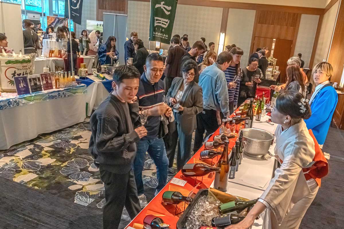 日本酒をはじめ、果実酒、ビールが並び、賑わう会場。ブースでは好みの味を伝えると、米の産地や精米歩合からぴったりの銘柄を勧めてくれる。2025年10月9日、バンクーバー市。提供　SABC／Photographer: John Lau