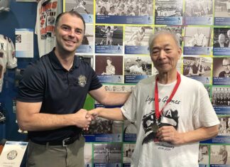 「朝日軍」初代団長の孫・松宮哲さん、BCスポーツ殿堂博物館を訪問 BCスポーツ殿堂博物館で、殿堂担当者のベックさん(左)と記念メダルを持つ松宮さん(右)。長年の交流を経て、歴史的な節目の日に訪問が実現した。2025年9月18日、バンクーバー市。撮影 田上麻里亜/日加トゥデイ