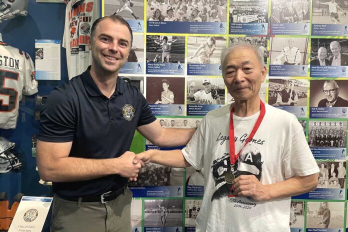 BCスポーツ殿堂博物館で、殿堂担当者のベックさん（左）と記念メダルを持つ松宮さん（右）。長年の交流を経て、歴史的な節目の日に訪問が実現した。2025年9月18日、バンクーバー市。撮影　田上麻里亜／日加トゥデイ