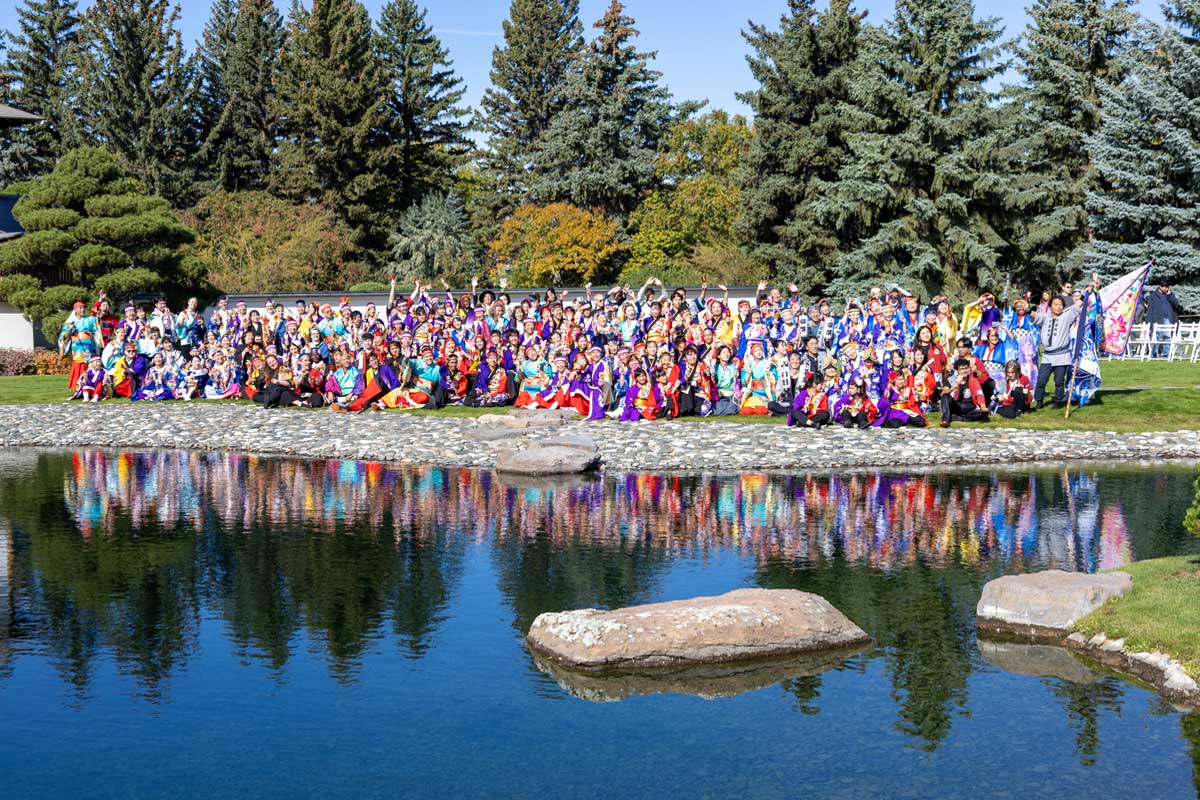 日加友好日本庭園という特別な舞台に、北米と日本からの踊り子たちが集結。池に映る衣装の彩りが秋空に美しく映えた。2025年9月28日、アルバータ州レスブリッジ市。提供: KOKUYOSA Project Committee