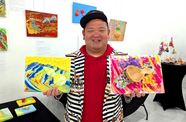 ひょうたんアーティストあらぽんさん、バンクーバーで展示会 作品を持つあらぽんさん。展示会場で。2025年9月1日、バンクーバー市。撮影 三島直美/日加トゥデイ