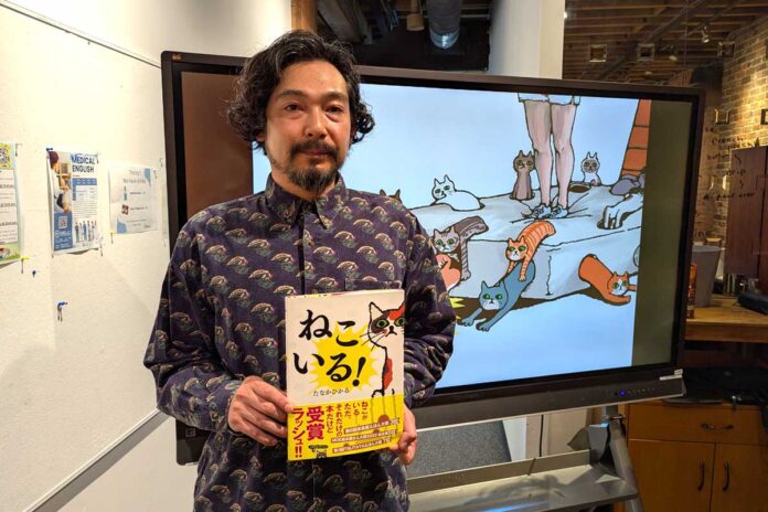 自作絵本を持って。田中光さん。2025年6月29日、バンクーバー市。撮影　三島直美／日加トゥデイ