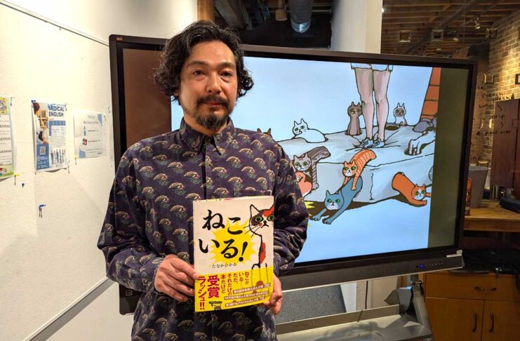「お笑いの発想を絵本に」絵本作家 田中光さんバンクーバーでワークショップ 自作絵本を持って。田中光さん。2025年6月29日、バンクーバー市。撮影 三島直美/日加トゥデイ