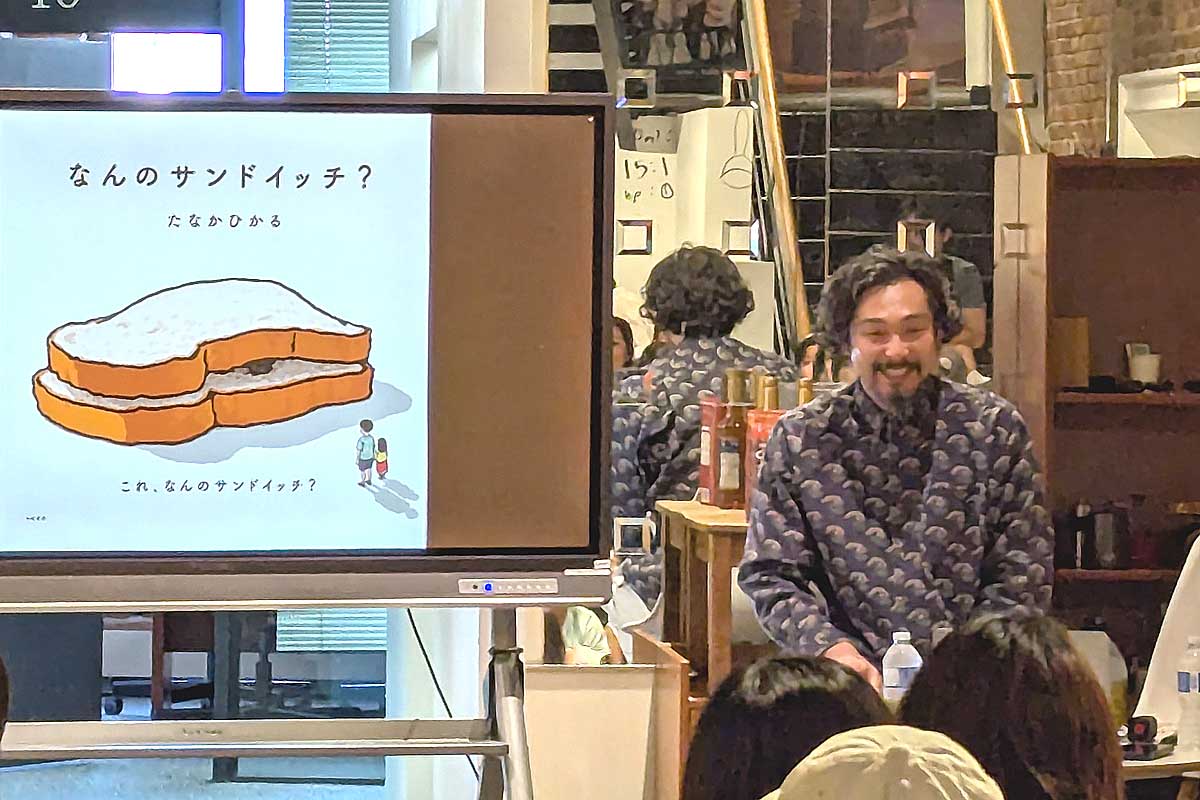 自身の絵本を使って読み聞かせをする田中さん。2025年6月29日、バンクーバー市。撮影　三島直美／日加トゥデイ