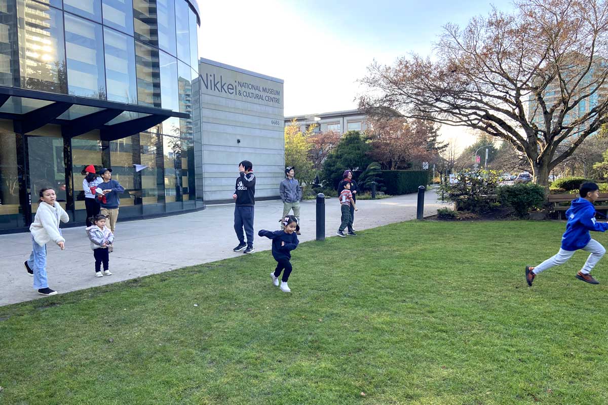 「紙ひこうきとばし」。前庭で思いっきり飛行機を飛ばしては駆け回る子どもたち。2025年11月30日、バーナビー市。撮影　宗圓由佳／日加トゥデイ