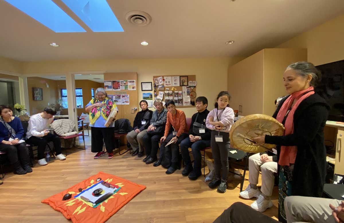 先住民長老、ケリー・ホワイトさんとノームさんの配偶者の鹿毛真理子さんがドラム演奏で日本からの参加者を歓迎。2025年11月22日。撮影 AK Jump Educational Consulting Inc.