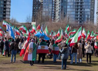 バンクーバーのイラン系コミュニティ、米国のイラン攻撃に歓喜 バンクーバー市デイビッド・ラム公園に集まったイラン系カナダ人コミュニティの人たち。太陽と剣を持つ獅子の紋章が中央に描かれた国旗が多く見られた。2026年3月1日、バンクーバー市。撮影 日加トゥデイ