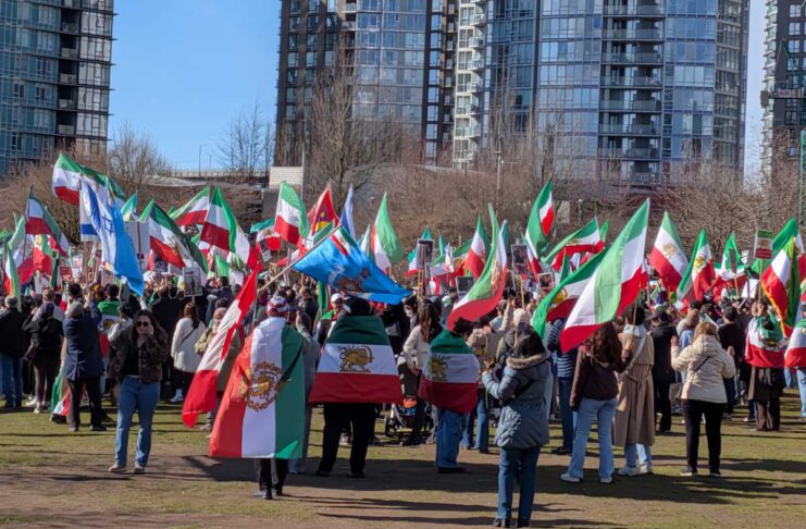 バンクーバーのイラン系コミュニティ、米国のイラン攻撃に歓喜 バンクーバー市デイビッド・ラム公園に集まったイラン系カナダ人コミュニティの人たち。太陽と剣を持つ獅子の紋章が中央に描かれた国旗が多く見られた。2026年3月1日、バンクーバー市。撮影 日加トゥデイ