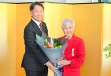 メアリー・キタガワさん旭日単光章受章、日系カナダ人の誇りを胸に 旭日単光章を胸に、両手に余るほどの大きな花束を髙橋総領事とともに持つ、キタガワさん。2026年5月22日、バンクーバー市。写真 斉藤光一/日加トゥデイ