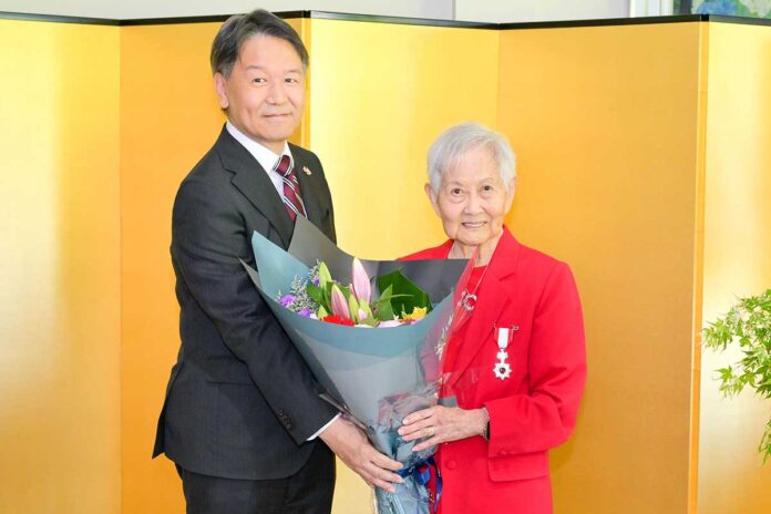 旭日単光章を胸に、両手に余るほどの大きな花束を髙橋総領事とともに持つ、キタガワさん。2026年5月22日、バンクーバー市。写真　斉藤光一／日加トゥデイ