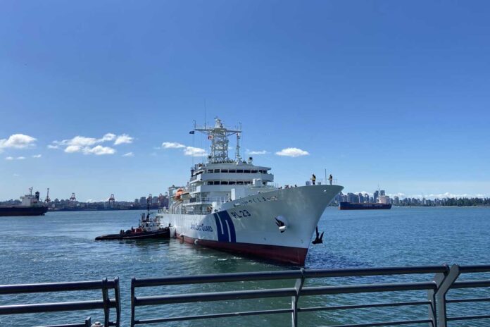 バンクーバー市ダウンタウンを背に、ノースバンクーバーのピアに入港する「いつくしま」。Japan Coast Guardの文字も。（2026年5月17日、ノースバンクーバー市。撮影　日加トゥデイ）