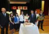 55年の世代を超えて グラッドストーン日本語学園祝賀同窓会 創立55周年を祝うケーキ。卒業生や髙橋良明総領事などに囲まれ、笑顔を見せる村上陽子学園長(右から4番目)。2026年5月30日、日系文化センターホール。写真提供 グラッドストーン日本語学園